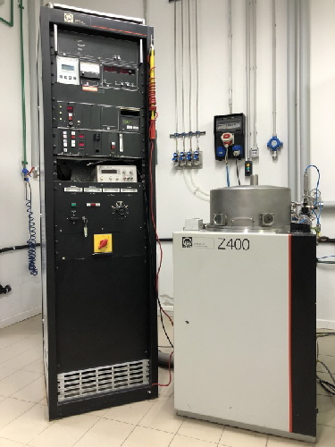 Sputtering process creating a glowing violet plasma inside a vacuum chamber